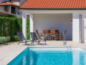a swimming pool with two chairs and a table at Holiday Home Florens - ROJ469 by Interhome in Sveti Petar u Šumi