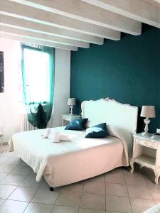 シルミオーネにあるLe Rêve B&B - Lake view roomsの緑の壁のベッドルーム1室(白いベッド1台付)
