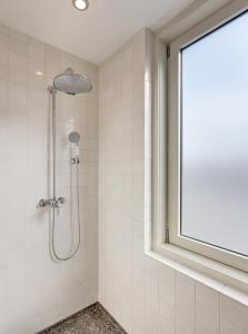 a shower in a bathroom with a window at Hotel V Nesplein in Amsterdam