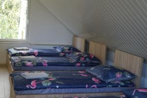 3 Betten in einem Zimmer mit Kissen darauf in der Unterkunft Domek K2 - Niezależny 5 osobowy - NoclegiGrodziskPL 792-535-535 in Grodzisk Mazowiecki