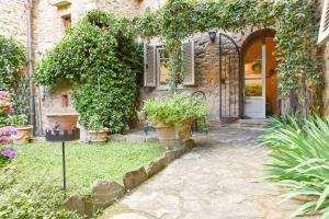 
a garden area with a stone wall and a brick building at Casa Amorino- Together Tuscany in Cortona
