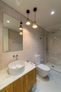 a bathroom with a sink and a toilet and a mirror at Gallery Hostel in Porto