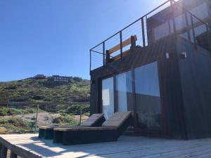 a building with a deck with a view of a hill at PUPUYA LODGE cabaña A, Matanzas in Matanzas