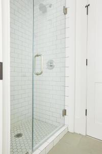 a glass shower with white subway tiles in a bathroom at Sonder at West Congress in Savannah