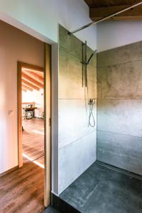 a glass shower in a room with a wooden floor at Roubenka u Huvarů in Tachov