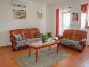 a living room with two leather couches and a coffee table at Holiday Home Marija by Interhome in Vicani