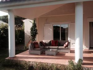 a couch sitting on a patio at Villa Quadradinhos 46Q Located close to the tennis courts and just 100m from the famous Restaurant in Vale do Lobo
