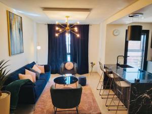 Luxueux appartement entre Gueliz et l'Hivernage avec WIFI في مراكش: غرفة معيشة مع أريكة زرقاء وطاولة