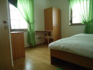 Schlafzimmer mit einem Bett, einem Schreibtisch und einem Fenster in der Unterkunft Lipizzaner Lodge Guest House in Postojna