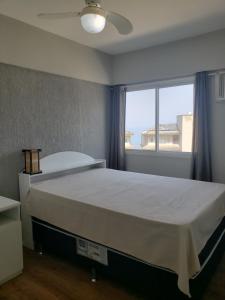 1 dormitorio con 1 cama grande y ventana grande en Porto Real Resort Apartmento, en Mangaratiba