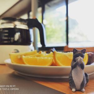 a figurine of a cat next to a plate of oranges at Taipei Jinguashi Cloud Mountain Homestay B&B in Jiufen