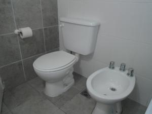 y baño con aseo blanco y lavamanos. en MONOambienteporDIA en Bahía Blanca