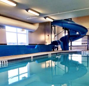 a swimming pool with a water slide in it at Sleep Inn Regina East in Pilot Butte