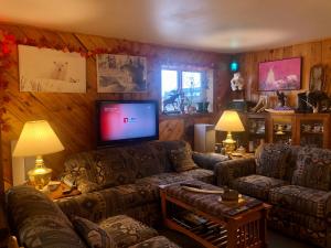 a living room with couches and a flat screen tv at IceBerg Inn in Churchill