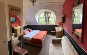 niewielka sypialnia z łóżkiem i oknem w obiekcie Berg Toboz Panzió w mieście Pecz