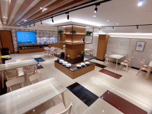 a large room with tables and chairs and a screen at Cai Mei Hotel in Dahu