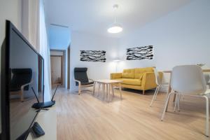 a living room with a yellow couch and chairs at Apartamento Colon en Cadiz in Cádiz
