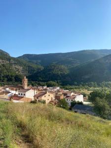 een dorp op een heuvel met bergen op de achtergrond bij Ca Ramonet in Arañuel