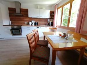 cocina con mesa de madera, mesa y sillas en Ferienhaus Troy, en Doren