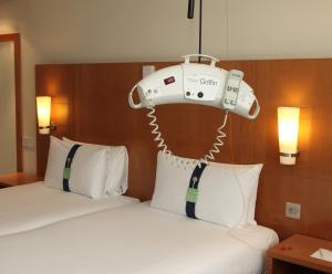 una habitación de hotel con una cama con una máquina colgada sobre ella en Holiday Inn Cardiff City, an IHG Hotel, en Cardiff