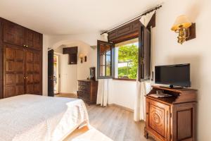 Dormitorio con cama y tocador con TV en Costa Dorada en Cala Gonone