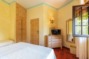 a bedroom with a bed and a dresser and a mirror at Costa Dorada in Cala Gonone