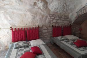 a bedroom with two beds in a stone wall at Le Refuge des Elfes in Bourré
