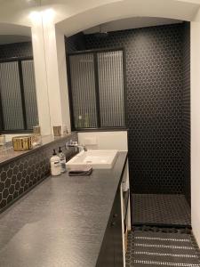 a bathroom with a sink and a black tile wall at Amstel Boutique Studio in Amsterdam