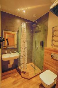 uma casa de banho com um chuveiro, um lavatório e um WC. em Sport Hotel em Cherkasy