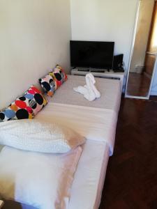 リスボンにあるフォンタナ ゲストハウスのベッド2台、薄型テレビが備わる客室です。