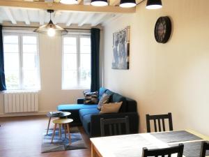 een woonkamer met een blauwe bank en een tafel bij Welk'Home Loft Rouen CHU - Coeur Historique in Rouen