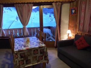モンジェネヴルにあるChalet Plein Sudのテーブルとソファ、窓が備わる客室です。