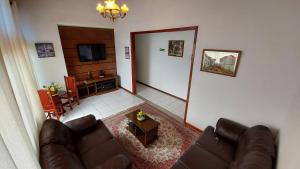 uma sala de estar com um sofá e uma mesa em Pousada Nativa's em São Luiz do Paraitinga