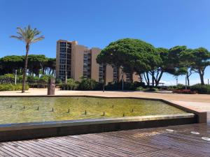 una fuente en un parque con árboles y edificios en PINEDA BEACH 1a línea de mar & parking, en La Pineda