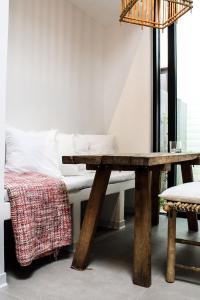 a wooden table with a bench next to a bed at Oscar in Ghent