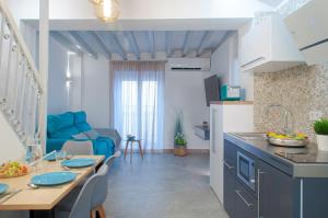a kitchen and living room with a table and a blue couch at ABAL Apartments - Barrio in Alicante