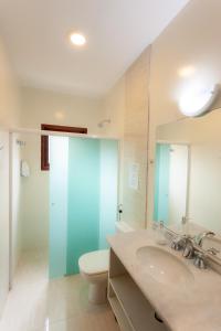 a bathroom with a sink and a toilet and a mirror at Ubatuba Ecologic Pousada in Ubatuba