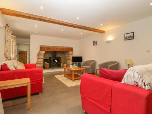 sala de estar con muebles de color rojo y chimenea en Dale Barton, en Wells