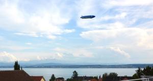 a plane flying in the sky over the water at Lakeview Penthouse in Meersburg