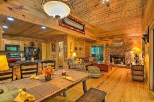een houten woonkamer met een tafel en een open haard bij Cozy Cabin with Deck, Walk to Wildcat Creek and Dining in Batesville