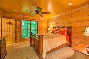 Schlafzimmer mit einem Bett und einem Deckenventilator in der Unterkunft Cozy Cabin with Deck, Walk to Wildcat Creek and Dining in Batesville
