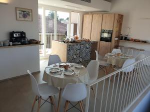 a dining room with two tables and white chairs at B&B Torreforte in Furnari
