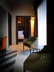 a hotel room with a couch and a table and a bed at Fifty House Cellini in Milan