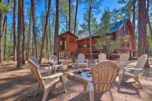 a cabin in the woods with chairs and a fire pit at Modern Pine Cabin with Game Room, Deck and Fire Pit! in Pine