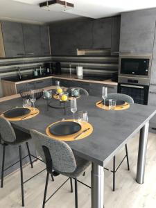 cocina con mesa grande con 4 sillas y mesa en NGI Vacances, en Malmedy