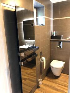 a small bathroom with a toilet and a sink at NGI Vacances in Malmedy