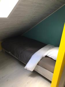 a bed in a room with a green wall at NGI Vacances in Malmedy