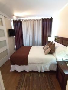 1 dormitorio con 1 cama grande y escritorio en M-Montt Providencia Apartamentos Amoblados, en Santiago