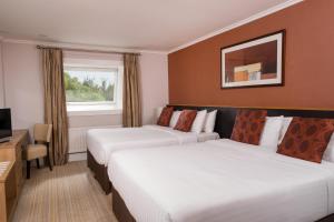 a hotel room with two beds and a television at Strangford Arms Hotel in Newtownards