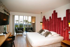 a hotel room with a bed and a desk and chairs at Hotel Onda in Calvi